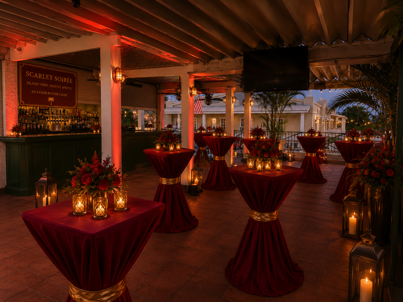 Scarlett Soirée rooftop cocktail tables dressed in deep scarlet linens with candlelight and floral centerpieces